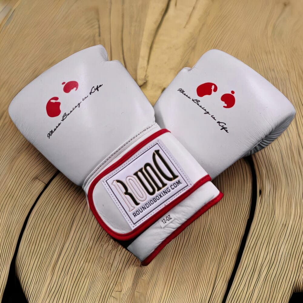 Two black boxing gloves on top of a wooden table.